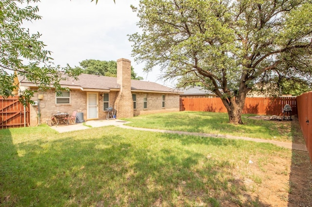 rear view of property with a patio and a lawn