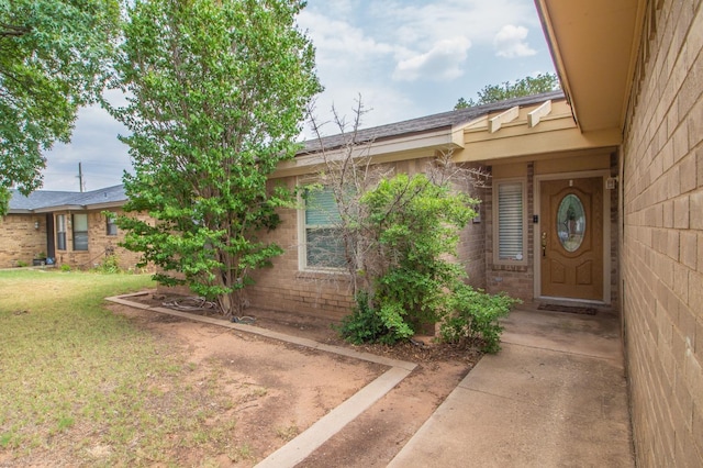 property entrance with a lawn