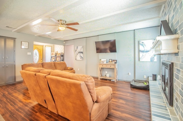 living room featuring dark hardwood / wood-style flooring, ceiling fan, a textured ceiling, and a fireplace