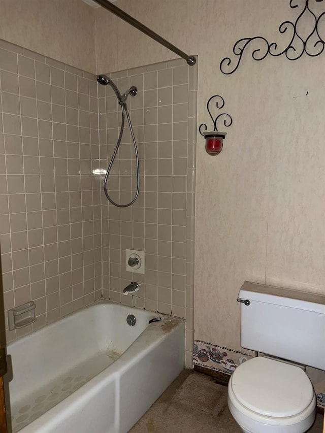 bathroom with tiled shower / bath combo and toilet