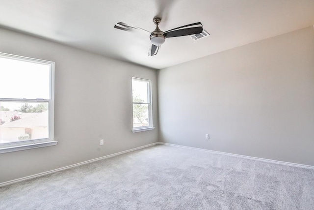 empty room with ceiling fan and light carpet