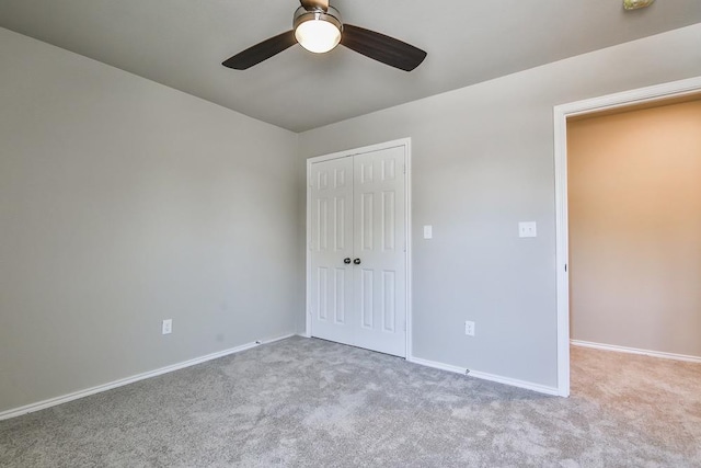 unfurnished bedroom with ceiling fan, a closet, and light carpet