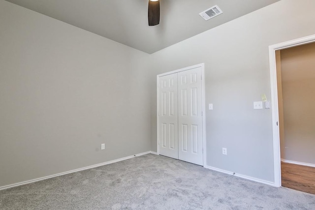 unfurnished bedroom featuring light colored carpet, a closet, and ceiling fan