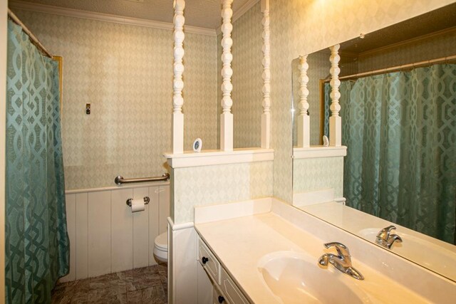 bathroom featuring crown molding, vanity, and toilet