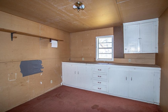 interior space featuring light carpet and white cabinets