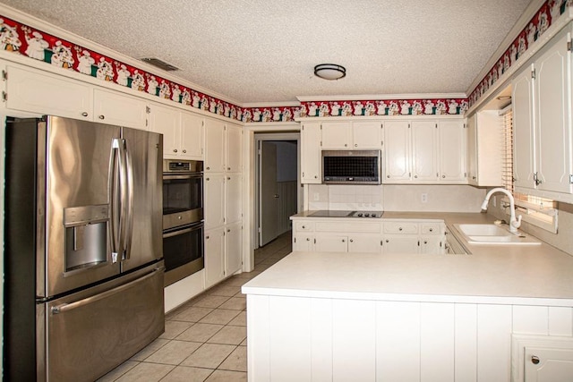 kitchen with sink, a textured ceiling, appliances with stainless steel finishes, kitchen peninsula, and white cabinets