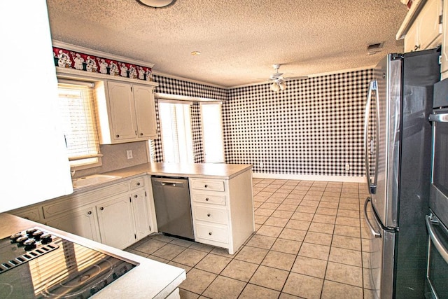 kitchen featuring light tile patterned flooring, appliances with stainless steel finishes, white cabinets, ceiling fan, and a textured ceiling