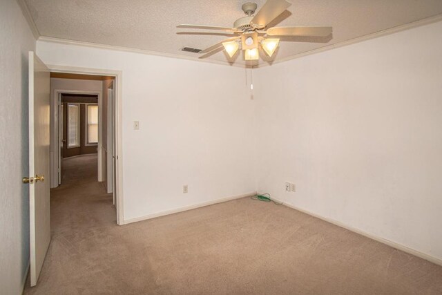 empty room featuring crown molding, light colored carpet, ceiling fan, and a textured ceiling