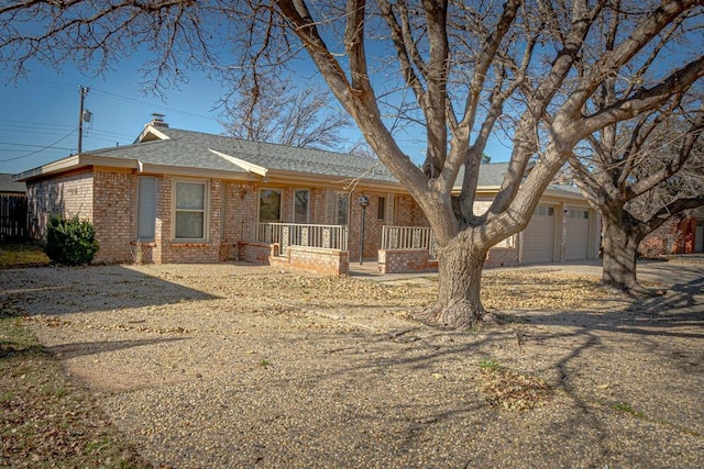 ranch-style home with a garage and covered porch