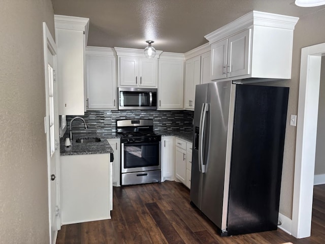 kitchen with sink, dark hardwood / wood-style floors, white cabinets, stainless steel appliances, and backsplash