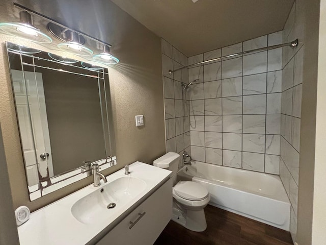 full bathroom featuring tiled shower / bath, wood-type flooring, toilet, and vanity