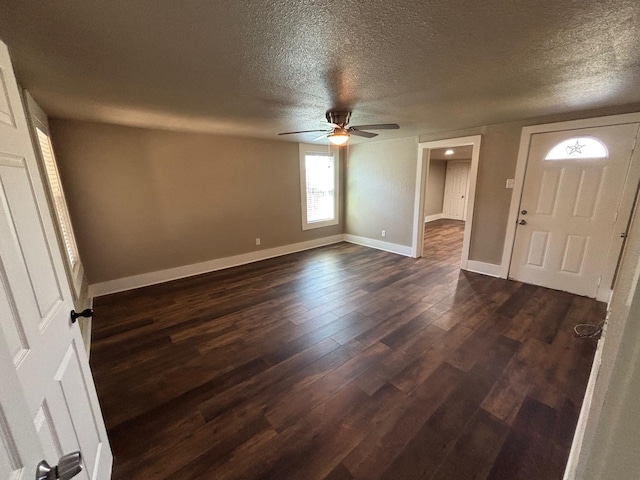 foyer entrance with ceiling fan, dark wood-type flooring, and a textured ceiling