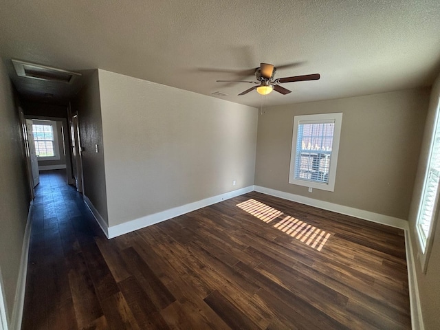 spare room with dark hardwood / wood-style flooring, ceiling fan, and a textured ceiling