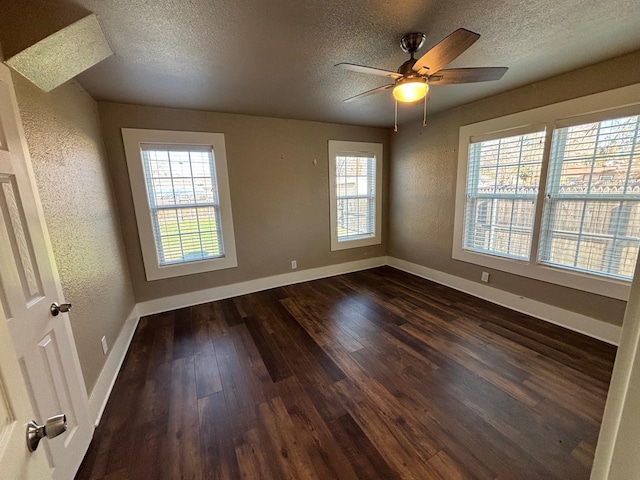 spare room with dark wood-type flooring, ceiling fan, and a textured ceiling