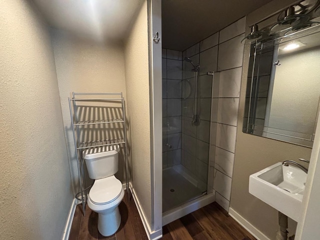 bathroom featuring an enclosed shower, sink, hardwood / wood-style flooring, and toilet