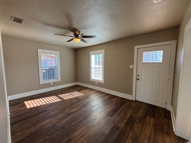 foyer with a textured ceiling, dark wood-type flooring, and ceiling fan