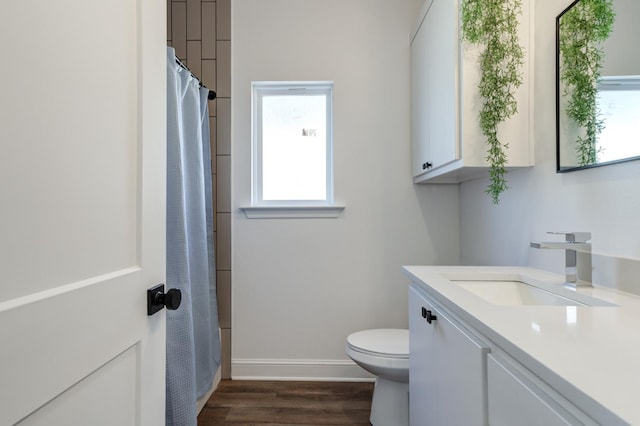 bathroom with vanity, toilet, baseboards, wood finished floors, and a shower with shower curtain
