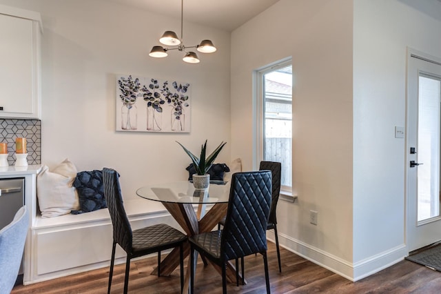 dining area featuring dark wood-style floors, baseboards, and an inviting chandelier