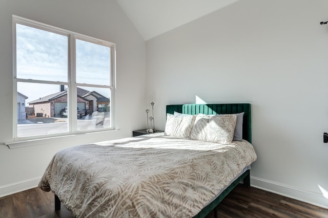 bedroom with lofted ceiling, wood finished floors, and baseboards