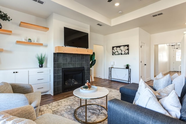 living area with visible vents, a chandelier, wood finished floors, and a fireplace