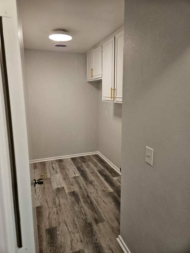 laundry room with baseboards and dark wood finished floors