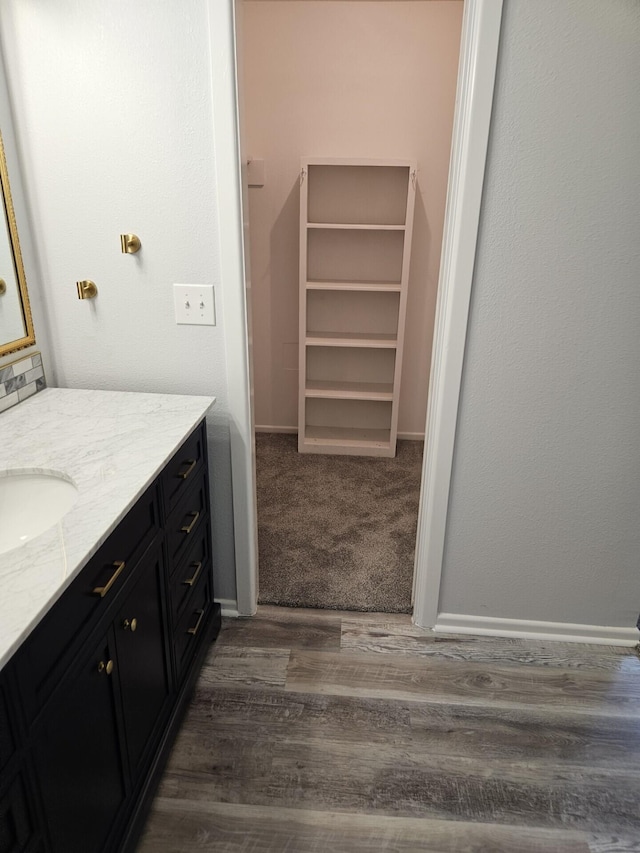 bathroom featuring vanity, wood finished floors, and baseboards