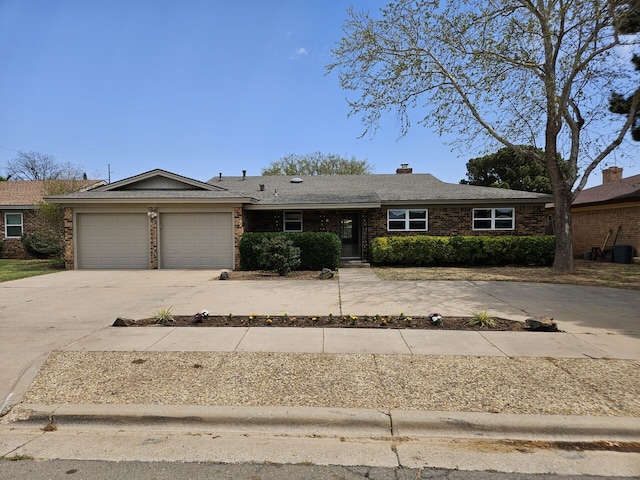 ranch-style house featuring driveway, a chimney, brick siding, and a garage