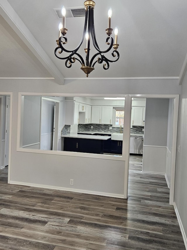 kitchen with ornamental molding, white cabinets, a chandelier, and dark wood-type flooring