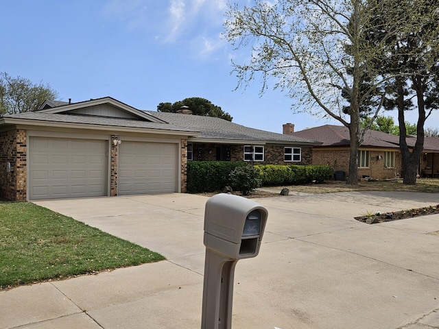 single story home with concrete driveway, an attached garage, brick siding, and a chimney