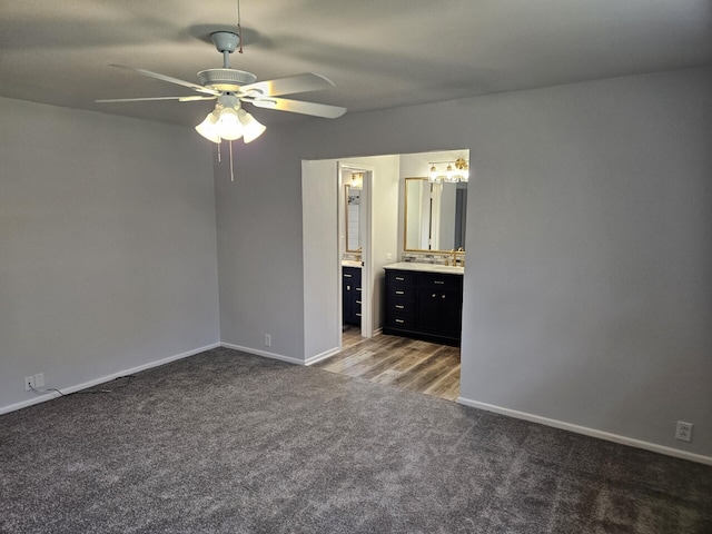 unfurnished bedroom with connected bathroom, ceiling fan, carpet floors, and baseboards