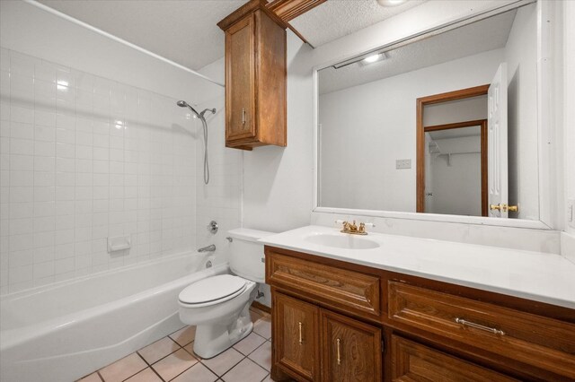 full bathroom featuring tile patterned flooring, vanity, a textured ceiling, toilet, and tiled shower / bath