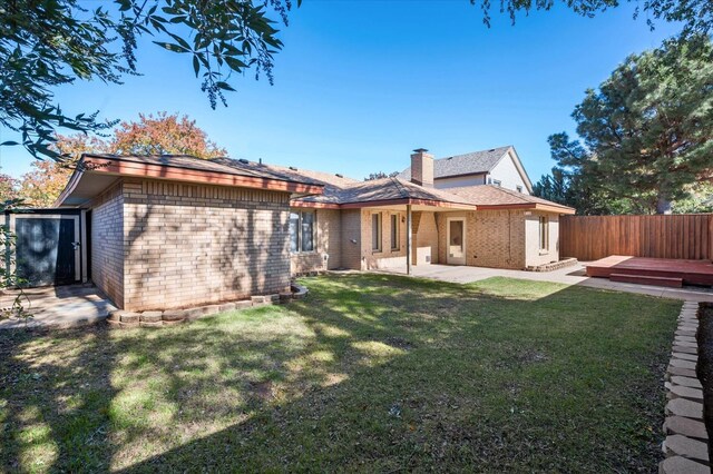 back of house with a lawn, a patio, and a deck