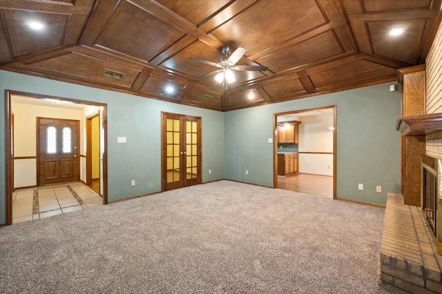 unfurnished living room with wood ceiling, coffered ceiling, light carpet, and french doors