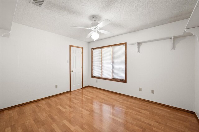 unfurnished room with ceiling fan, light hardwood / wood-style flooring, and a textured ceiling