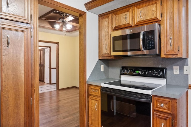 kitchen featuring ceiling fan, black electric range oven, backsplash, and light hardwood / wood-style floors