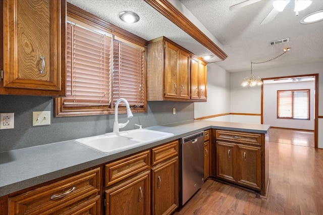 kitchen with sink, hanging light fixtures, dishwasher, kitchen peninsula, and light hardwood / wood-style floors