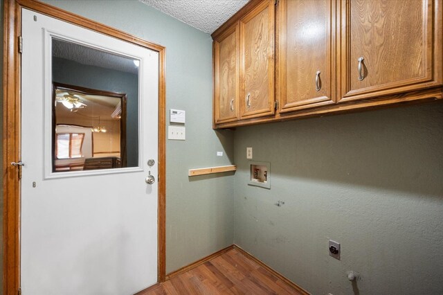 laundry room featuring light hardwood / wood-style flooring, cabinets, washer hookup, a textured ceiling, and hookup for an electric dryer