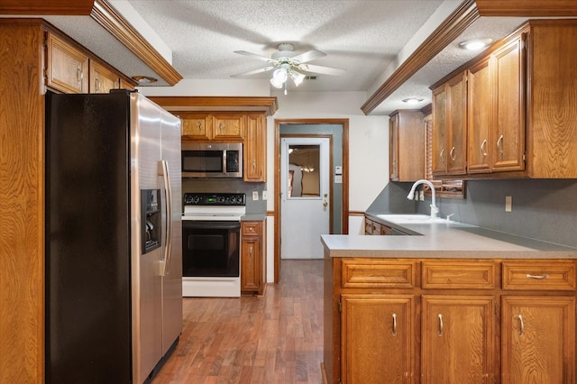 kitchen featuring sink, dark hardwood / wood-style flooring, ceiling fan, stainless steel appliances, and a textured ceiling