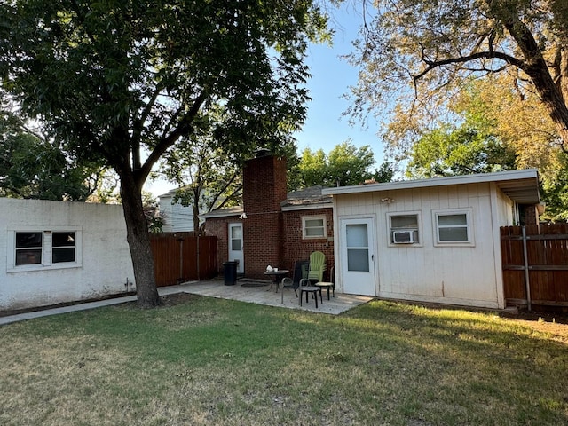 rear view of property featuring a yard and a patio area