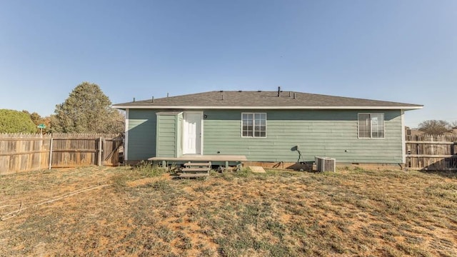 back of property featuring a yard and central air condition unit