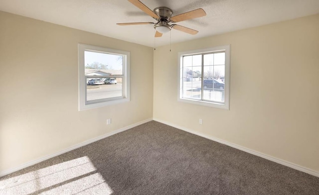 carpeted empty room with ceiling fan and plenty of natural light