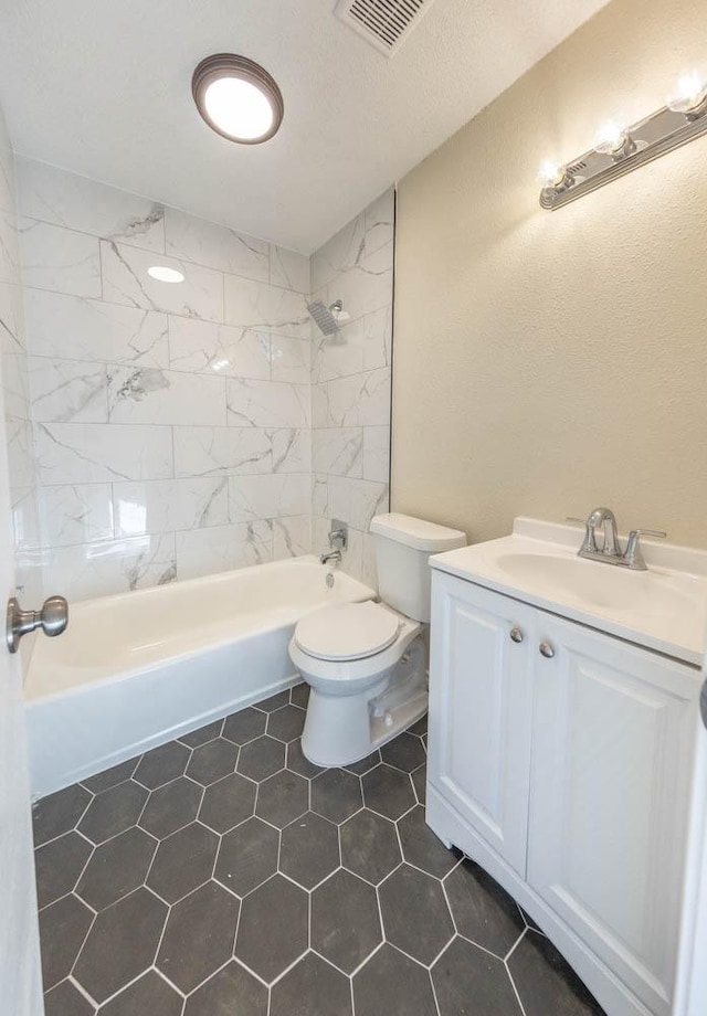 full bathroom featuring tiled shower / bath, vanity, and toilet