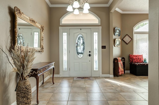 tiled entrance foyer with a notable chandelier and ornamental molding