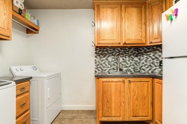 washroom with washer / dryer, sink, and light tile patterned floors