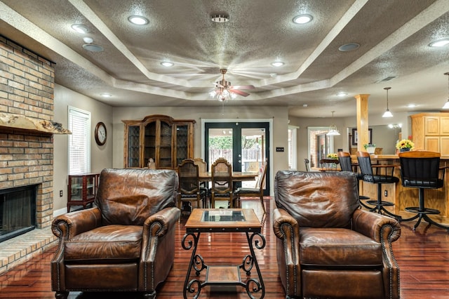 living room featuring a fireplace, dark hardwood / wood-style floors, and a textured ceiling