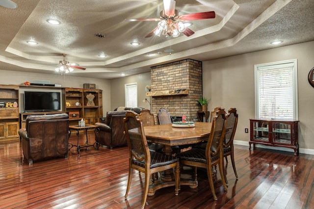 dining room with dark hardwood / wood-style floors and a raised ceiling