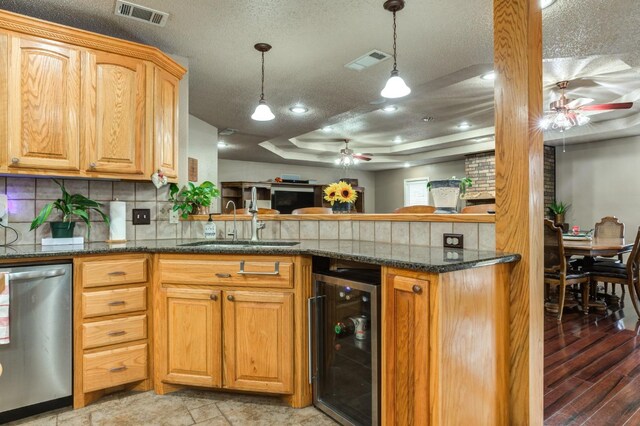 kitchen with a raised ceiling, dishwasher, beverage cooler, and ceiling fan