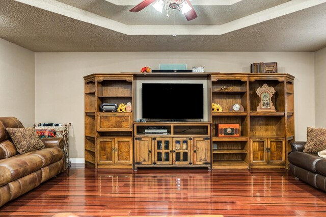 living room featuring dark hardwood / wood-style flooring, a textured ceiling, and ceiling fan