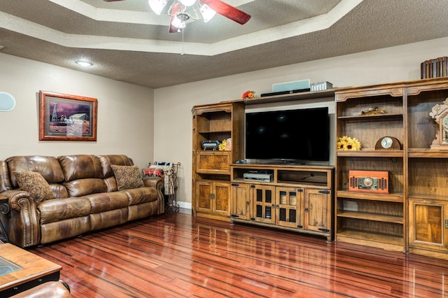 living room featuring hardwood / wood-style flooring, a textured ceiling, and ceiling fan