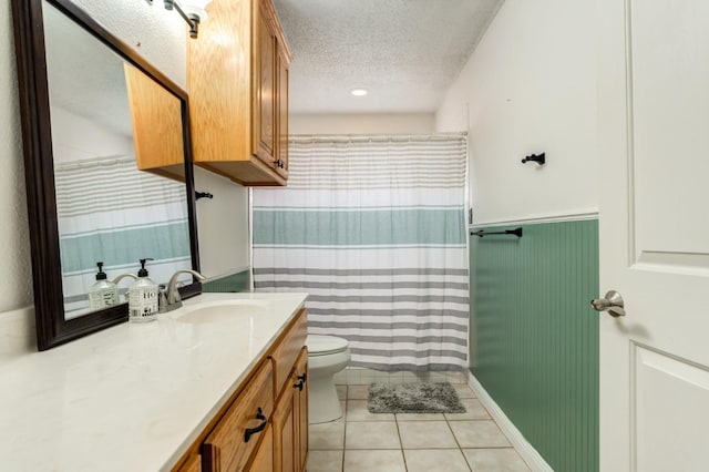 bathroom featuring tile patterned floors, toilet, a textured ceiling, and vanity